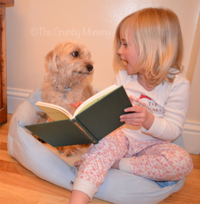 Reading her dog a bedtime story