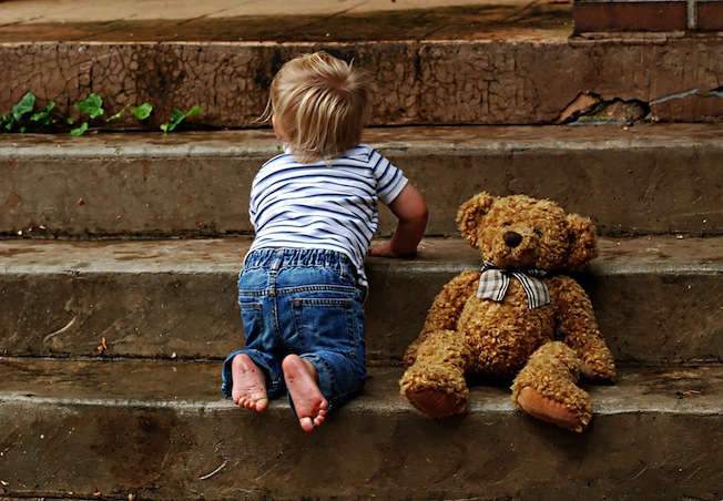 toddler on steps with teddy